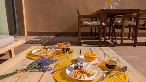 une table avec des assiettes de nourriture et de boissons dessus dans l'établissement ASTER spa & beach dúplex, à La Vila Joiosa