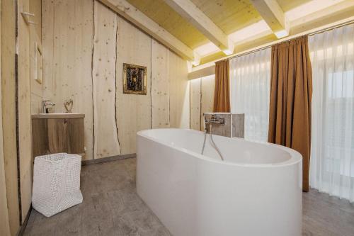 a large white tub in a bathroom with a sink at Ferienwohnung AUSZEIT mit Wellnessnutzung in Ainring