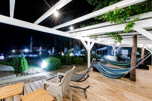 a couple of hammocks on a deck at night at OŚRODEK KOLONIJNO WCZASOWY MEWA - przy plaży z basenem z podgrzewaną wodą i mini SPA in Niechorze