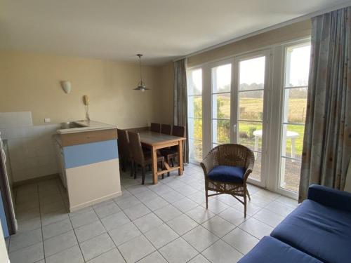 - un salon avec une cuisine et une table avec des chaises dans l'établissement Belle Dune Quartier Les Eaux Vives, à Fort-Mahon-Plage