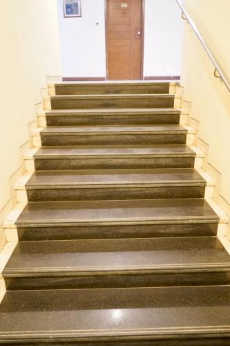 a set of stairs in a building with a door at The Sky Comfort, Ahmedabad in Ahmedabad