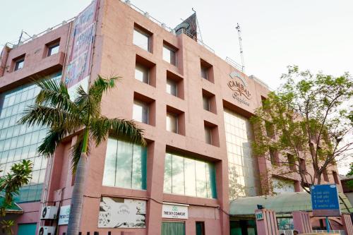 a building with a palm tree in front of it at The Sky Comfort, Ahmedabad in Ahmedabad