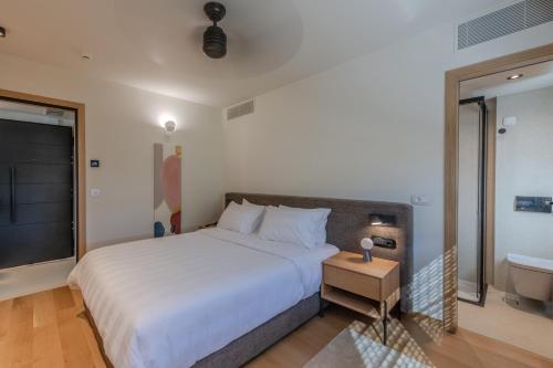 a bedroom with a large bed and a bathroom at Ilva Suites in Nafplio