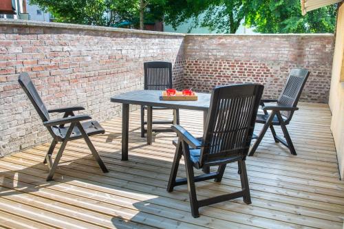 une table et quatre chaises sur une terrasse en bois dans l'établissement Chill & Sun - Terrace and parking, à Amiens