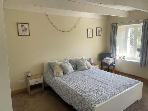 une chambre avec un lit avec des oreillers et une fenêtre dans l'établissement St Thois, à Saint-Thois