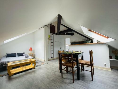 une chambre avec un lit, une table et des chaises dans l'établissement Logement cosy et plein de charme - 382, à Rouen