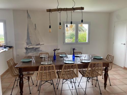 une salle à manger avec une table et des chaises en bois dans l'établissement Kistillig, à Landéda