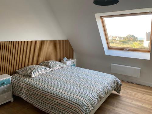 a bedroom with a bed with a window and a bed sidx sidx sidx at Kistillig in Landéda