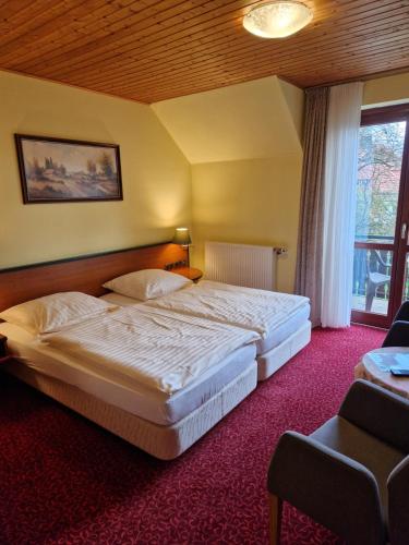 a hotel room with two beds and a window at Hotel & Apartmenthaus Zum Pfingsttor in Friedrichswald