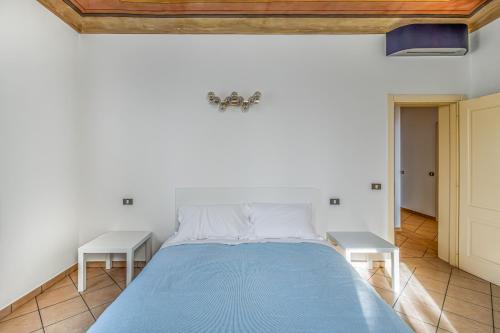 a bedroom with a blue bed with two tables at GuestHost - Cozy Flat X4 in a Historic Silk Mill in Modena