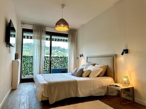 une chambre avec un lit et une grande fenêtre dans l'établissement Elégant et spacieux 3 pièces, centre Cannes, à Cannes