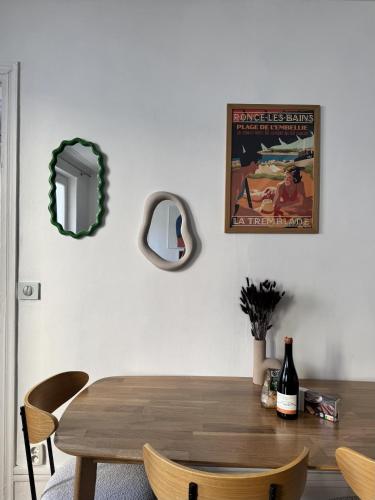 - une salle à manger avec une table en bois et un miroir dans l'établissement Batignolles-Montmartre / Mathieu, à Paris