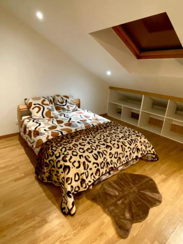 - une chambre dotée d'un lit avec une couverture à motifs léopards dans l'établissement Chez Bartoch, à Boulogne-sur-Mer