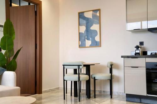 a kitchen with a table and two stools at Ain Diab Ocean Breeze & Parking in Casablanca