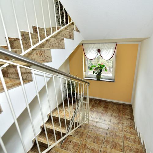 a staircase in a house with a window at Pension Schwesinger in Ottendorf-Okrilla
