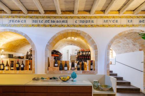 a wine shop with two arches and bottles of wine at Baglio Siciliamo Country House in Noto Marina