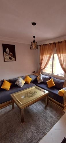 un salon avec un canapé bleu avec des coussins jaunes dans l'établissement Résidence Nadia 3 étage appartement 22, à Marrakech