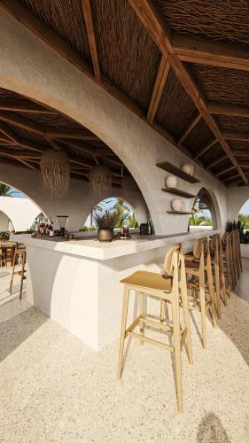 a restaurant with a bar with chairs and a table at Neem - Raw Luxury Boutique Hotel Madiha - adults only in Kamburugamuwa