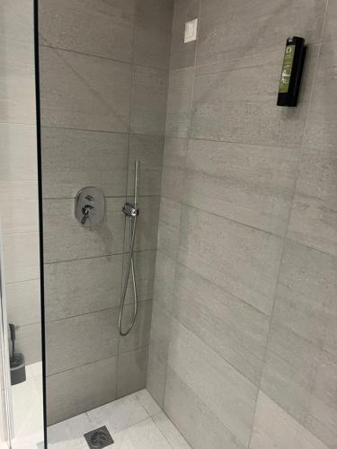 a shower stall with a glass door with a shower at OSIRIS HOTEL APARTMENTS and STUDIOS in Ialyssos