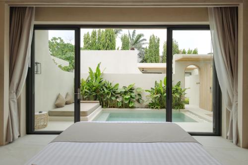 a bedroom with a bed and a large window at Eden Resort & Villas Phuket Patong in Patong Beach