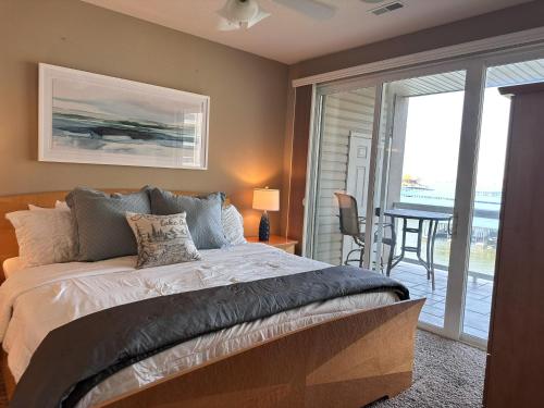 ein Schlafzimmer mit einem Bett und ein Balkon mit einem Tisch in der Unterkunft Lakefront Lands End Luxury 3bed2bathpools in Osage Beach