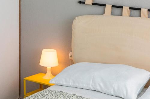 a bed with a white pillow next to a lamp at Casa Annunziata - Bronte in Bronte