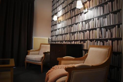 a room with two chairs and a wall of books at Domaine de Joinville in Eu