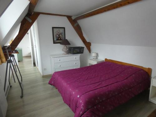 - une chambre avec un lit et une couverture violette dans l'établissement Gîte Les Ronces, à Conteville