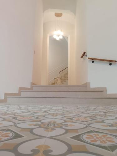 a room with a rug on the floor and stairs at Palazzo Annarita in Brindisi