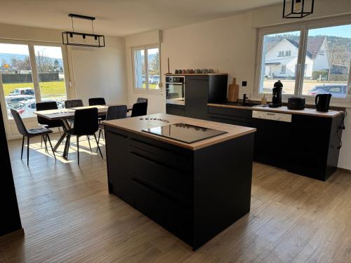 une cuisine et une salle à manger avec une table et des chaises dans l'établissement Chambre Eté avec baignoire privée, à Anould