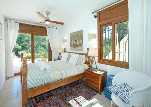 ein Schlafzimmer mit einem Bett und einem Fenster in der Unterkunft Villa Ceylon by Vintage Travel in Tamariu