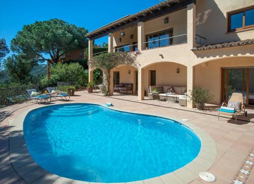 ein großer blauer Swimmingpool vor einem Haus in der Unterkunft Villa Ceylon by Vintage Travel in Tamariu