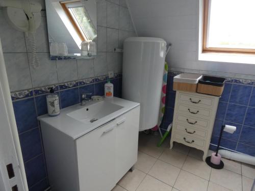 La petite salle de bains est pourvue d'un évier et d'un réfrigérateur. dans l'établissement Gîte Les Ronces, à Conteville