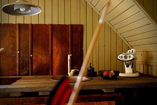 a kitchen with a counter with a sink and a lamp at Pelēkā Māja, summer house for cosy stays in Myza Brenguli