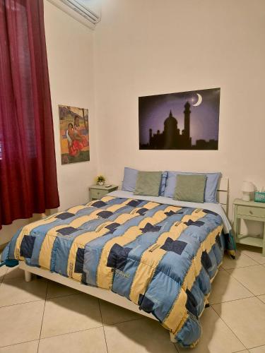 a bedroom with a bed with a blue and yellow comforter at B&B IL POETA in Palermo
