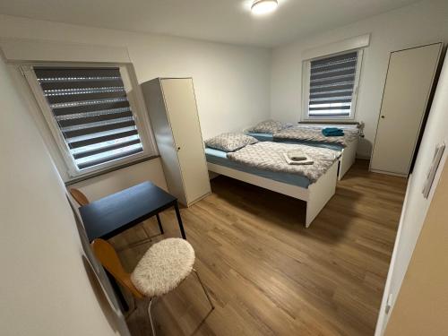 a small room with two beds and a chair at Grenz Oase in Gronau