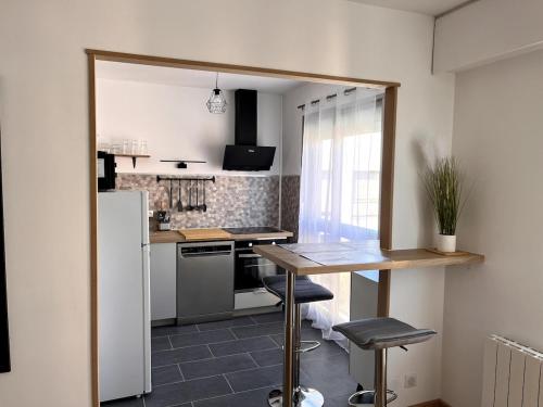 une petite cuisine avec une table et un réfrigérateur dans l'établissement Bel appartement cosy Chartres, à Chartres