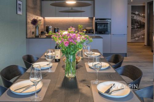 een eettafel met een vaas met bloemen erop bij LIVALPIN Balance in Garmisch-Partenkirchen