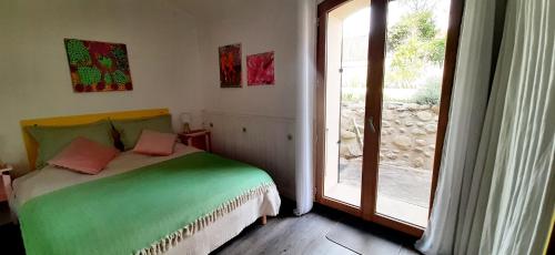- une chambre avec un lit à côté d'une porte coulissante en verre dans l'établissement Gîte de charme dans Mas Catalan, à Prades