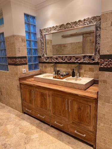 a bathroom with a sink and a large mirror at Suara Jiwa Luxury Villas with Private Pool in Ubud