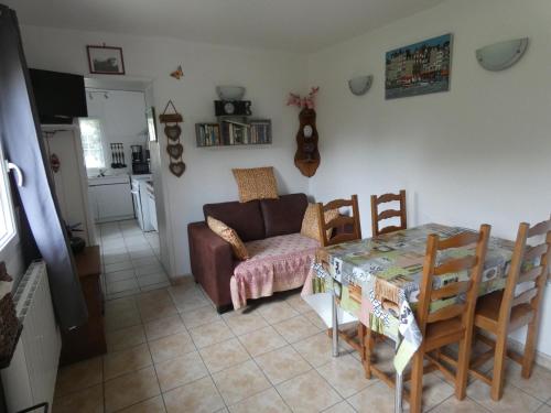 un salon avec une table et un canapé dans l'établissement Gîte Les Ronces, à Conteville