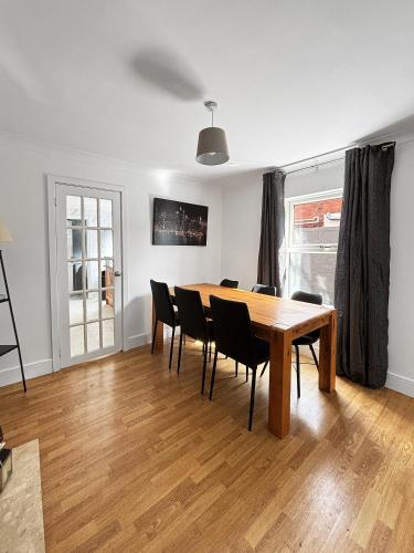 a dining room with a wooden table and chairs at NEW 3 Bed House Sleeps 8 Ideal for Groups, Families & Contractors - Garden & Driveway - Central Location - Amaya 10 in Lincolnshire