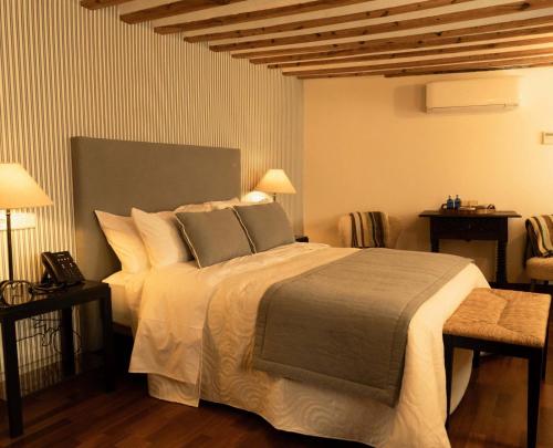 a bedroom with a large bed and two lamps at Casón del Conde in Orgaz