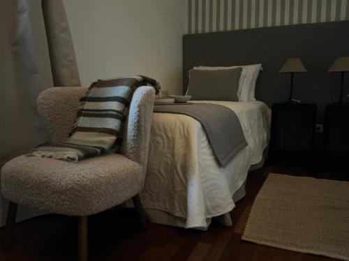 a bedroom with a bed and a chair at Casón del Conde in Orgaz