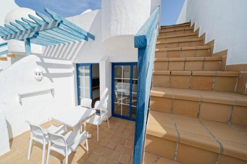 a staircase leading up to a house with a table and chairs at LABRANDA Bahía Fañabé & Villas in Adeje