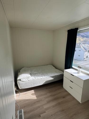 a small bedroom with a bed and a window at Apart, 4 pers, Central in Odda in Odda