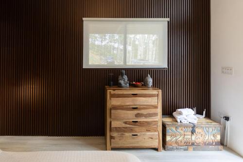 a bedroom with a wooden dresser and a window at Cozy Hideaway in the Mountains of Altos de María in Lagartero