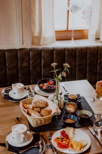 a table with plates of food and a basket of bread at Berg-Leben in Grossarl
