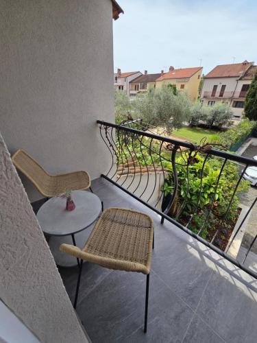 a balcony with two chairs and a table and a railing at H&H Rooms Rovinj - Adults Only in Rovinj