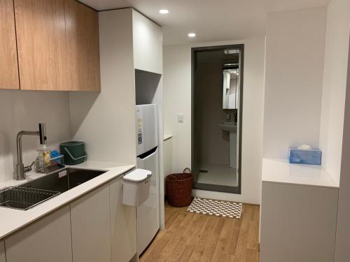 a white kitchen with a sink and a refrigerator at Mangwon Hangang Park House 3 rooms or one room in Seoul